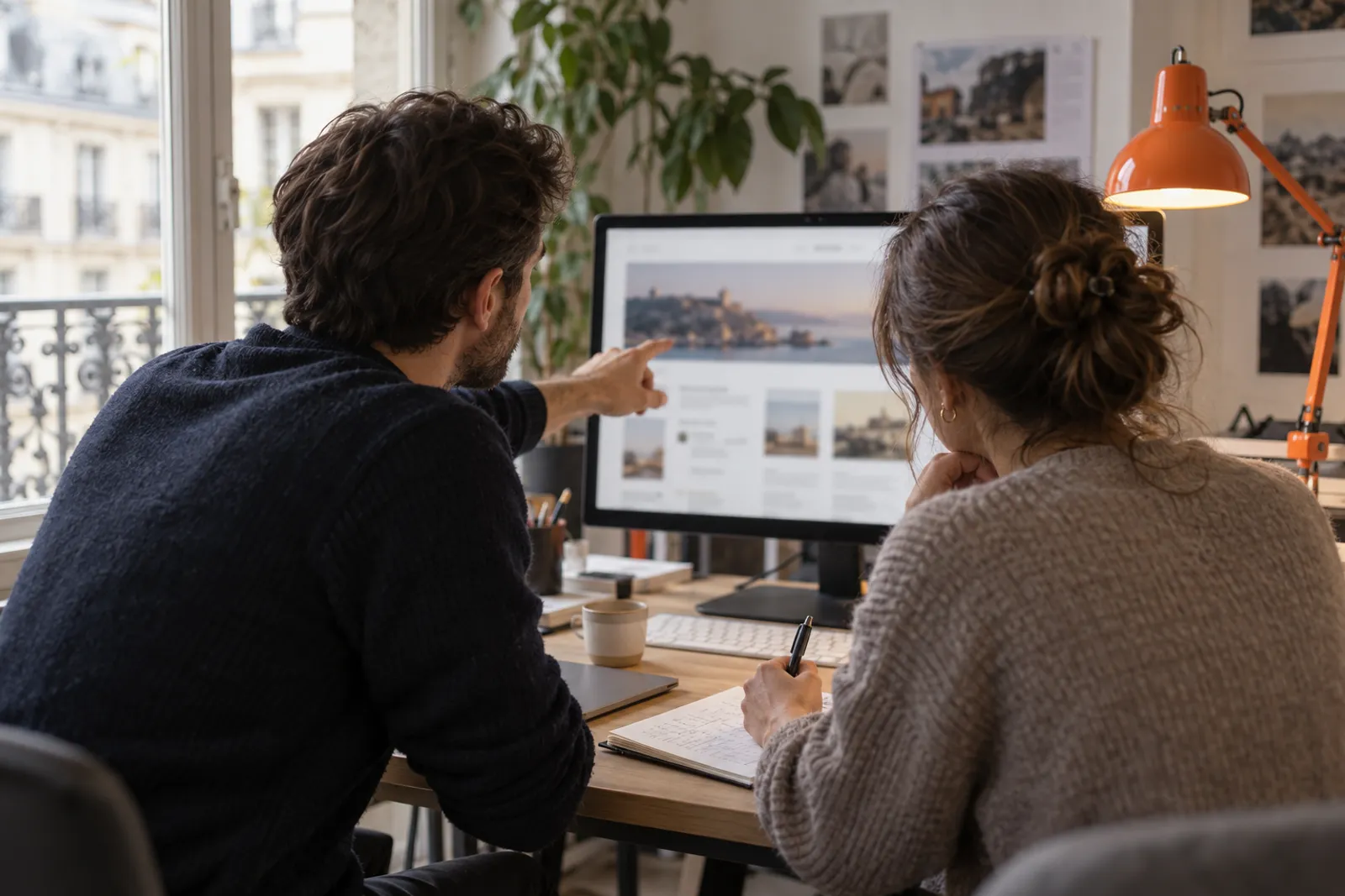 Deux consultants examinent ensemble le site d’un client sur un grand écran.