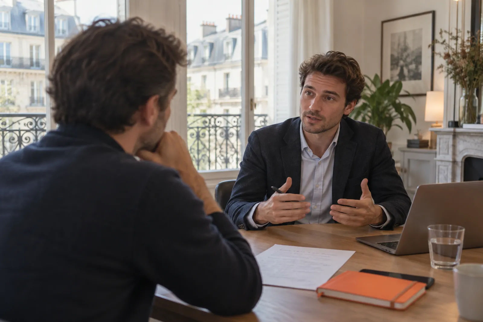 Un dirigeant fait passer un entretien à un prestataire, sa liste de questions posée sur la table.